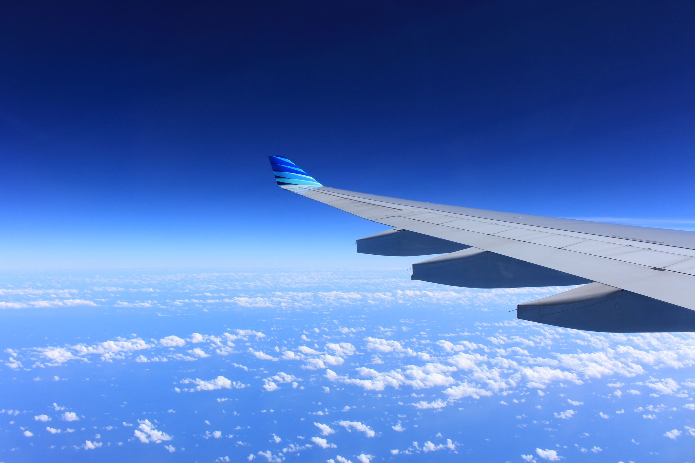Airplane wing above the clouds on an international flight